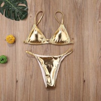 a gold bikini set on a wooden table