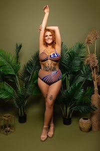 a woman in a bikini posing in front of plants