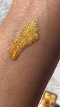 a woman's arm with gold glitter on it